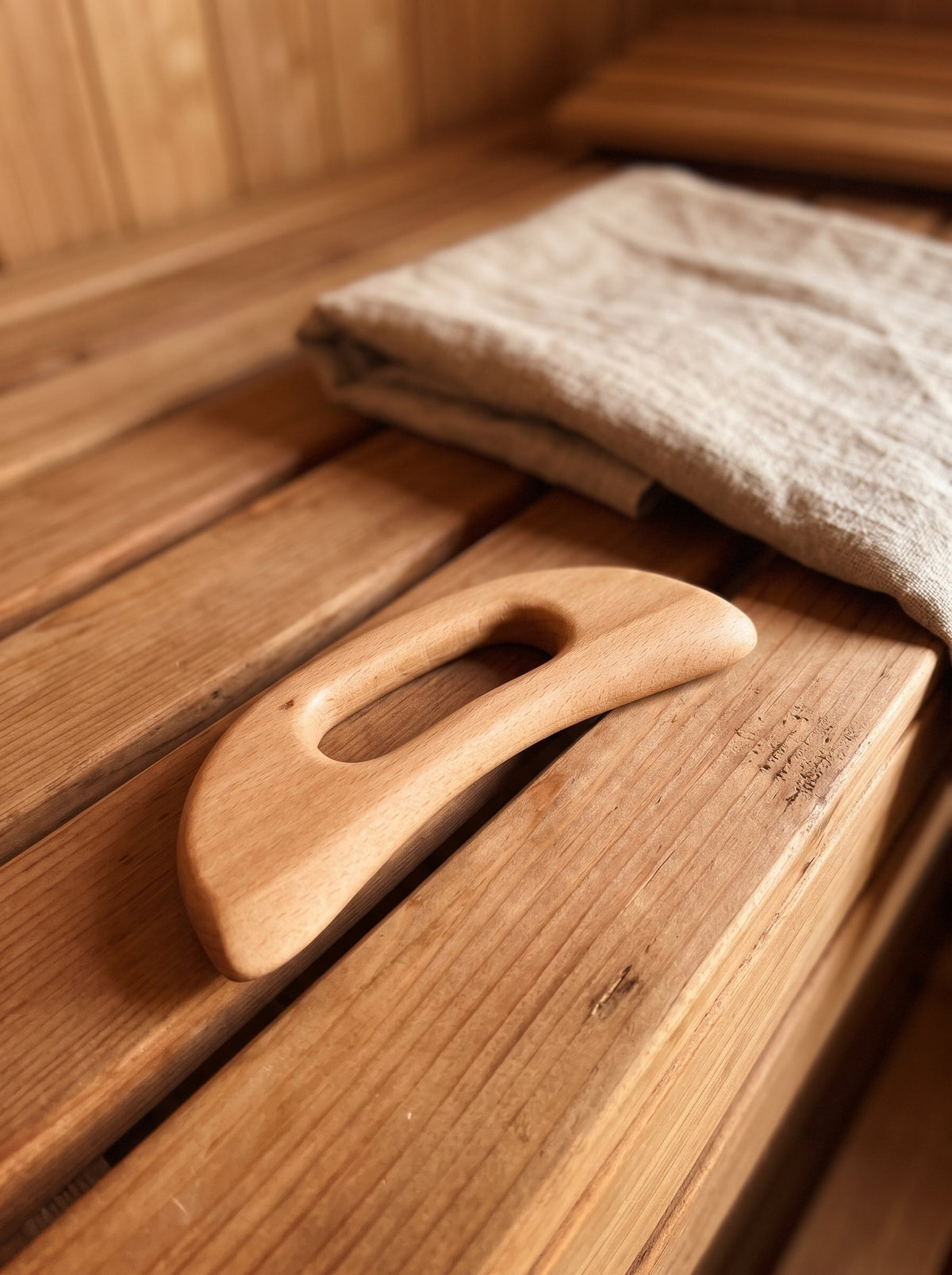 Beechwood body scraper on a cedar sauna bench
